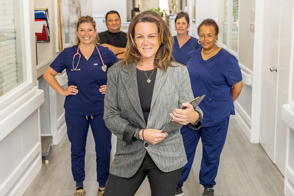 Staff members standing in hallway and smiling